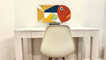 A white desk with a chair in front of it.