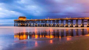 A pier extending into calm waters with a building at the end.