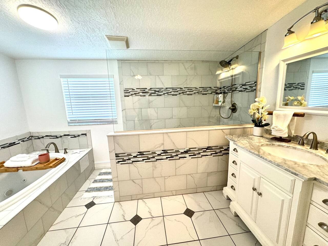 Une salle de bain comprenant une baignoire, un meuble-lavabo et un espace douche.