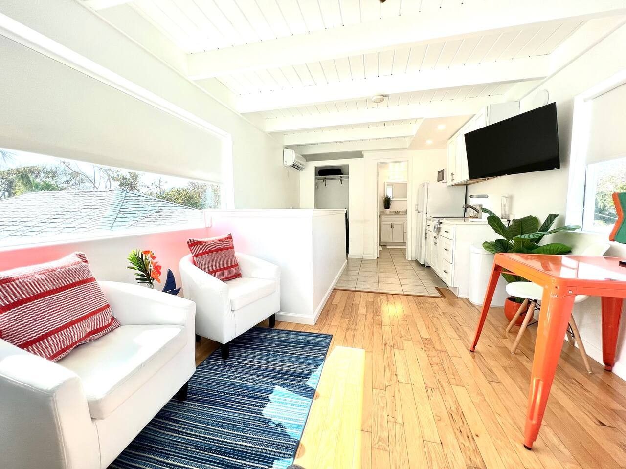 Una sala de estar moderna con un sofá, una mesa de centro y un televisor montado en la pared.