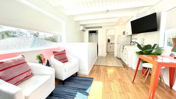 Una sala de estar moderna con un sofá, una mesa de centro y un televisor montado en la pared.