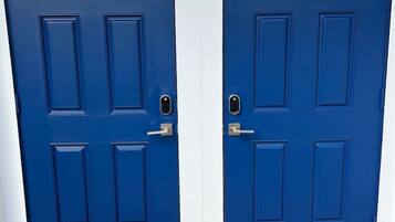 Dos puertas azules con molduras blancas, cada una con cerradura y pomo.
