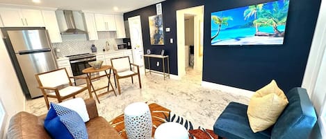 A modern living room with a sofa, coffee table, and a TV mounted on the wall.