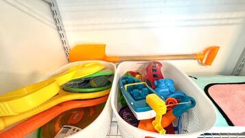 Ein Lagerbereich mit verschiedenen Gegenständen, darunter Plastikbehälter, ein Netz und ein Spielzeug.