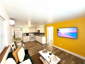 A modern apartment with a kitchen, dining area, and living room. - 1 bdrm:beach across st, Port  8 mi, Ron Jon’s 4 mi (Cocoa Beach)