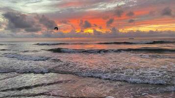Una playa con olas y un atardecer.