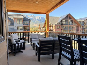 A balcony with outdoor seating and a view of mountain buildings. - New | Modern Mountain Retreat | Walk to Town (Canmore)