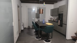 Una cocina moderna con comedor, refrigerador y una lámpara colgante.