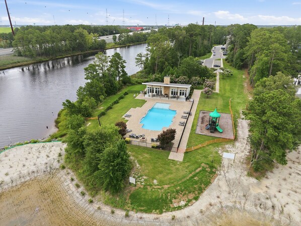A residential property with a swimming pool, a fenced yard, and a view of a river.