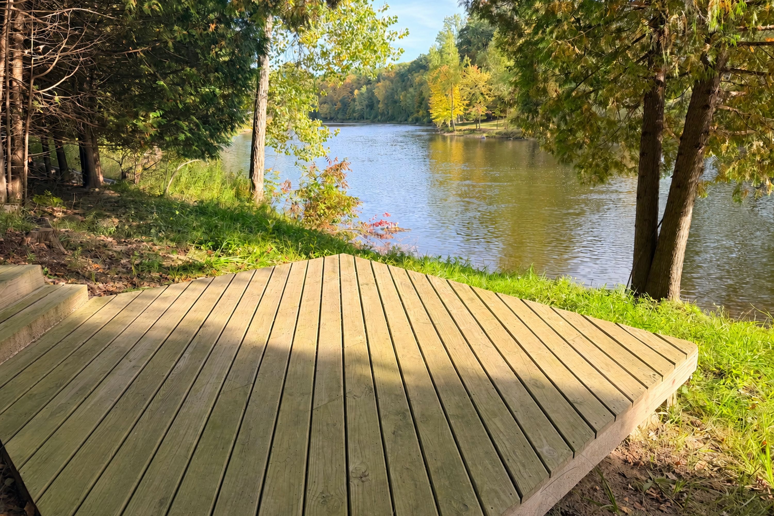 Una terraza de madera con vista a un río tranquilo flanqueado por árboles.