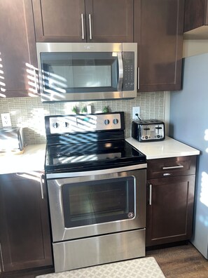 A kitchen with a stainless steel microwave, oven, and toaster. - 🌿 JAVA HOUSE | Private Stay, No Sharing • Free Coffee, Breakfast & Parking (Edmonton)