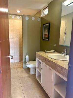A bathroom with a toilet, sink, and shower. - Excellent location (Puerto Vallarta)