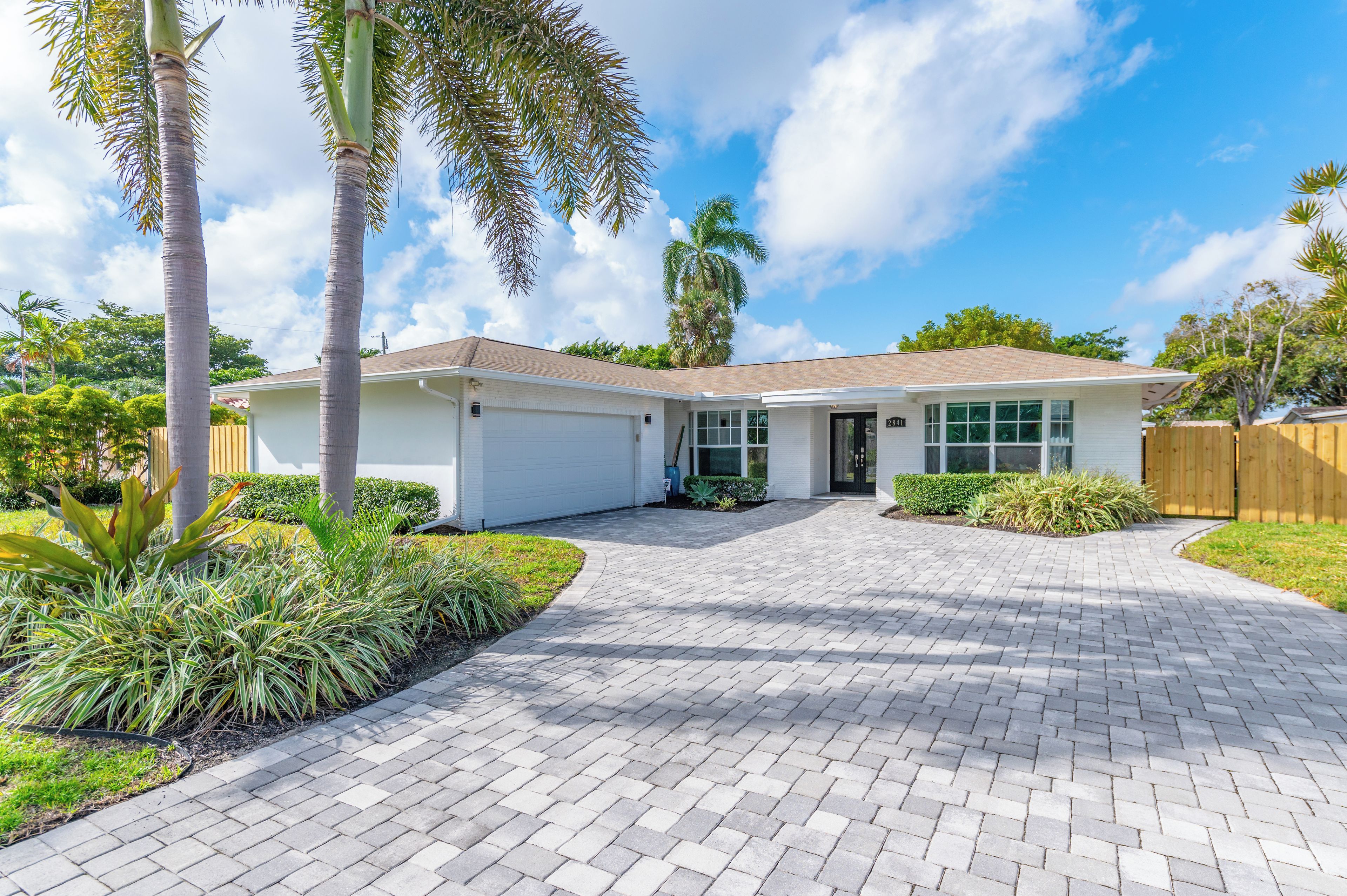 A single-story house with a garage, a driveway, and a well-maintained lawn.