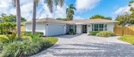 A single-story house with a garage, a driveway, and a well-maintained lawn.