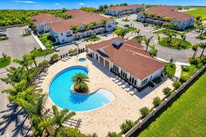 A residential complex with a swimming pool, multiple houses, and a well-maintained lawn. - 15mins Disney~Themed Suites~Resort Pool~Game Room (Kissimmee)