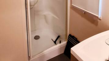 Une salle de bain avec une douche, un lavabo et des toilettes.
