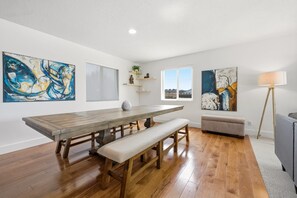 A dining area with a wooden table, benches, and artwork on the walls. - The Perfect Pace - Park City Vacations (Park City)