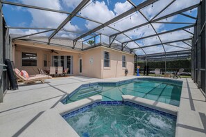 A covered swimming pool with lounge chairs and a ceiling fan. - Luxury 6-Bed Villa with Pool & Spa near Disney (Davenport)