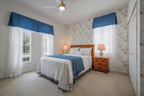 A bedroom with a bed, two nightstands, a ceiling fan, and floral wallpaper. - Luxury 6-Bed Villa with Pool & Spa near Disney (Davenport)