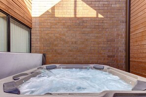 A hot tub with a brick wall backdrop and wooden paneling. - Park Avenue 311 - Park City Vacations (Park City)