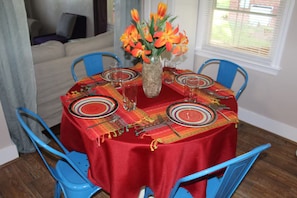 A dining table set with plates, glasses, and a vase of flowers. - Not Your Normal Nana & Papa's Place 3 bdrm/1 bath (Columbus)