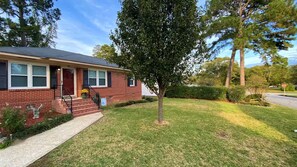 A residential house with a brick exterior, a front porch, and a well-maintained lawn. - Not Your Normal Nana & Papa's Place 3 bdrm/1 bath (Columbus)