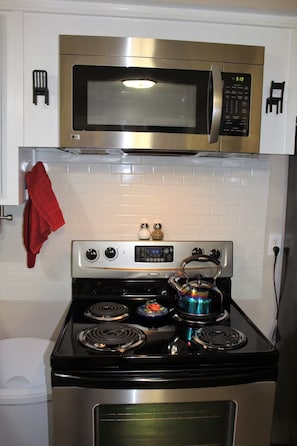 A kitchen with a stainless steel microwave, stove, and oven. - Not Your Normal Nana & Papa's Place 3 bdrm/1 bath (Columbus)