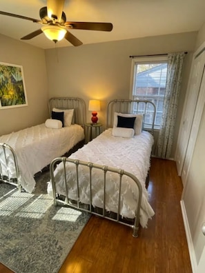 A bedroom with two metal beds, a ceiling fan, a window with curtains, and a rug. - Robin's Nest 3 bed/1 bath/15 mins to Ft Benning (Columbus)