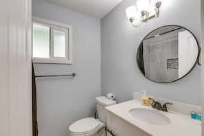 Un bagno con il water, un lavandino e uno specchio.