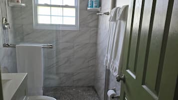 A bathroom with a shower, toilet, and sink.