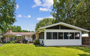 A house with a covered patio, a barbecue grill, and a lawn. - Palm & Pine  (Ocean Springs)