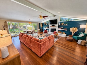 A spacious living room with a sectional sofa, a fireplace, and a television. - Palm & Pine (Ocean Springs)