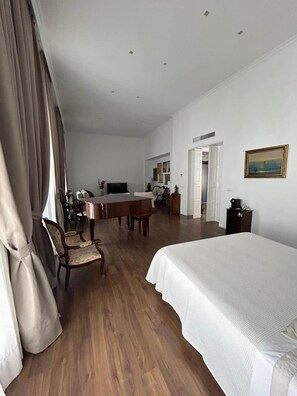 Une chambre d’hôtel avec un lit, un bureau, une chaise, une télévision et un tableau au mur.