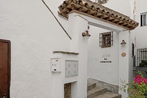 A narrow street with a white building, a wooden door, and a sign reading 'EL ARRIATE'. - Studio Apartment 'El Arriate De Vejer - Estudio' with Wi-Fi (Vejer de la Frontera)