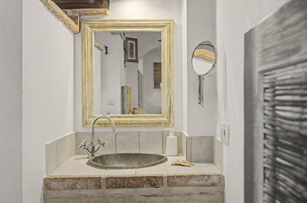 Une salle de bain équipée d’un lavabo, d’un miroir et d’un porte-serviettes.