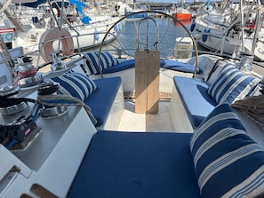 A boat deck with seating areas, a mast, and various nautical equipment.