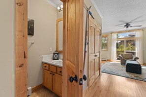 A bathroom with wooden cabinets, a white sink, and a mirror. - New 2-bedroom townhome with private hot tub (Silverthorne)