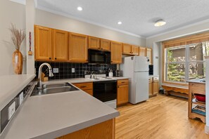 Una cucina moderna con mobili in legno, lavello in acciaio inossidabile e forno integrato.