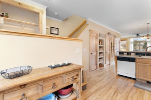 Una cucina con mobili in legno, lavastoviglie integrata e zona pranzo con tavolo e sedie di legno.