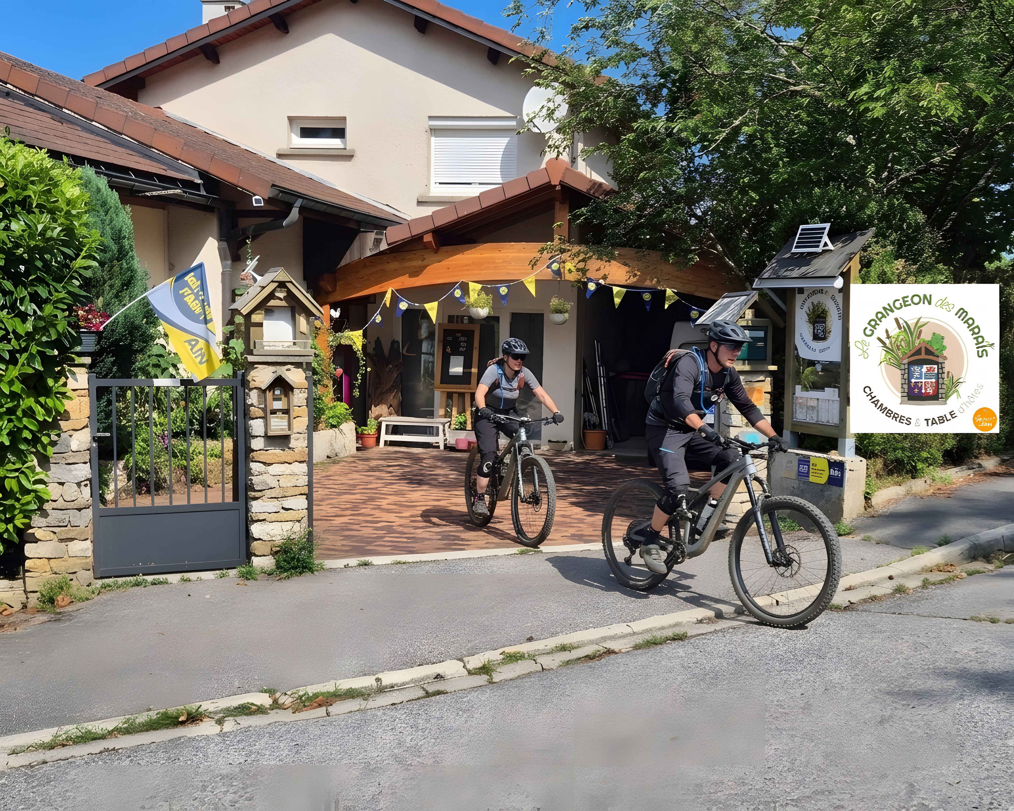 Un bâtiment avec une entrée en pierre, un petit drapeau et une enseigne.