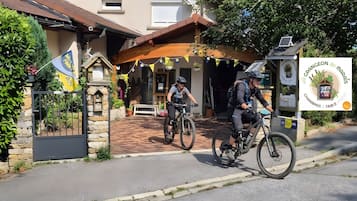 Un bâtiment avec une entrée en pierre, un petit drapeau et une enseigne.