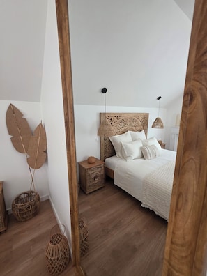 A bedroom with a bed, bedside tables, and decorative wall art.