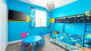 A room with a bunk bed, a TV, a desk, and chairs. - Family Villa w/ Themed Rooms, Pool & Resort Access (Davenport)