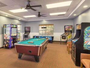 A pool table in a room with arcade games and a window. - Cozy 1-bedroom condo Branson (Branson)