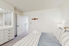 A bedroom with a bed, a dresser, a mirror, and a door leading to another room. - Cozy Retreat on Sleeping Bear Dunes & Lake Michigan Views (Glen Arbor)