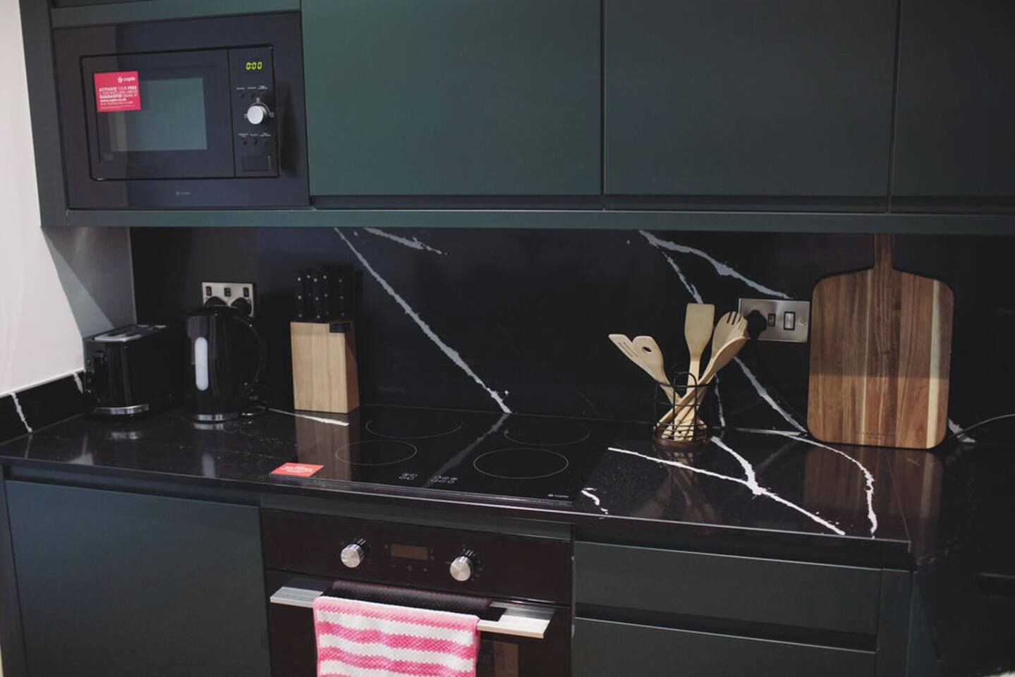 Une cuisine équipée d’un four à micro-ondes, d’une cuisinière et de divers ustensiles.