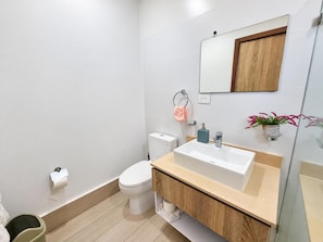 A modern bathroom with a toilet, sink, and mirror. - Ocean View Sunrise 2BR Navio Los Corales C403 (Bávaro)
