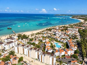 A coastal resort area with beachfront hotels, a marina, and clear blue waters. - Ocean View Sunrise 2BR Navio Los Corales C403 (Bávaro)