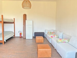 A room with a bunk bed, a refrigerator, a sofa with floral cushions, and a hanging light fixture. - Stunning villa with a pool in the Umbria Valley (Gualdo Cattaneo)