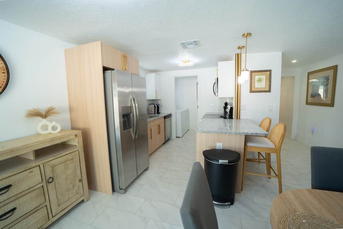 A modern kitchen with a refrigerator, stove, and wooden cabinets.